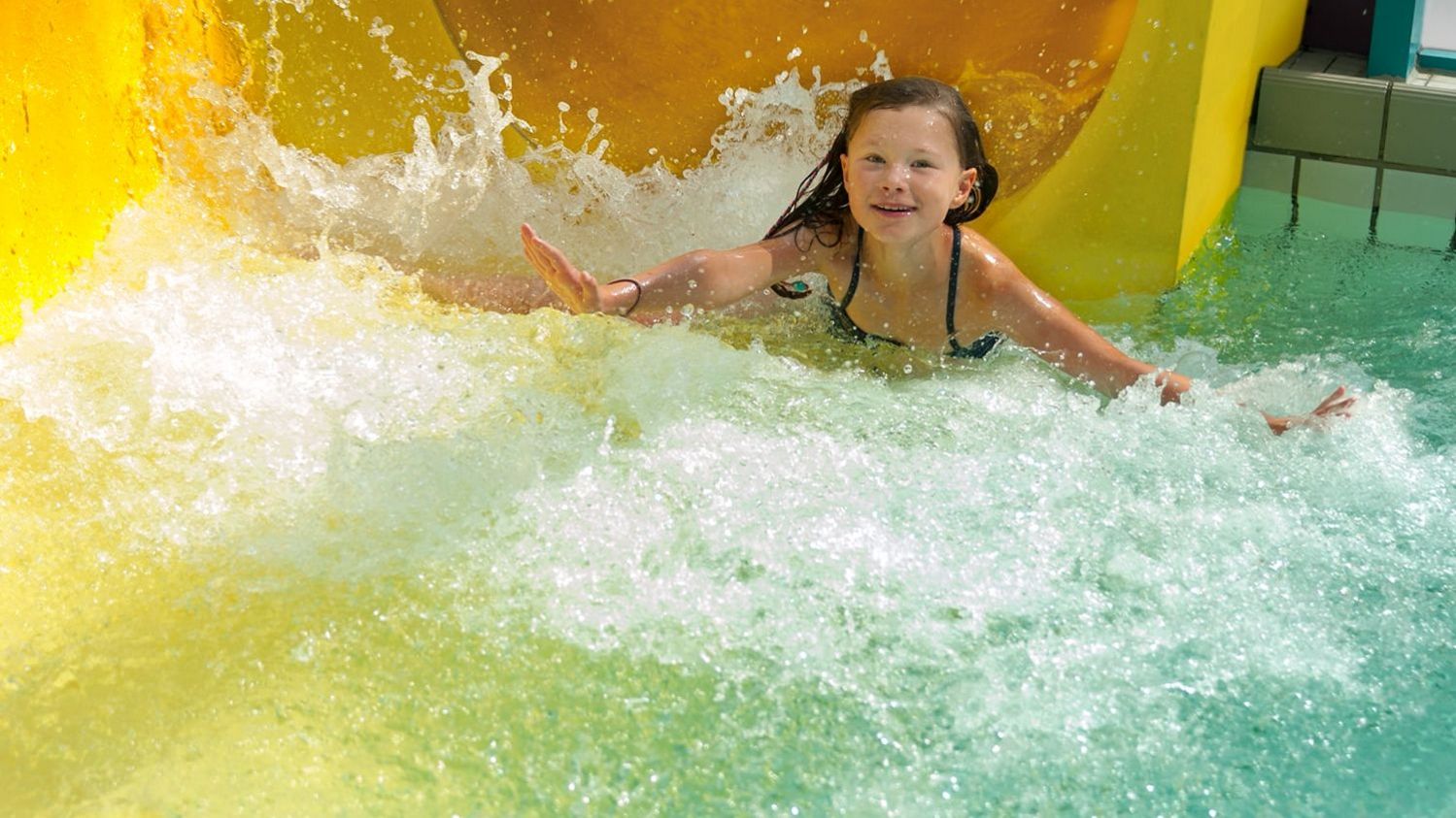 Mädchen rutscht aus der Riesenrutsche ins Becken