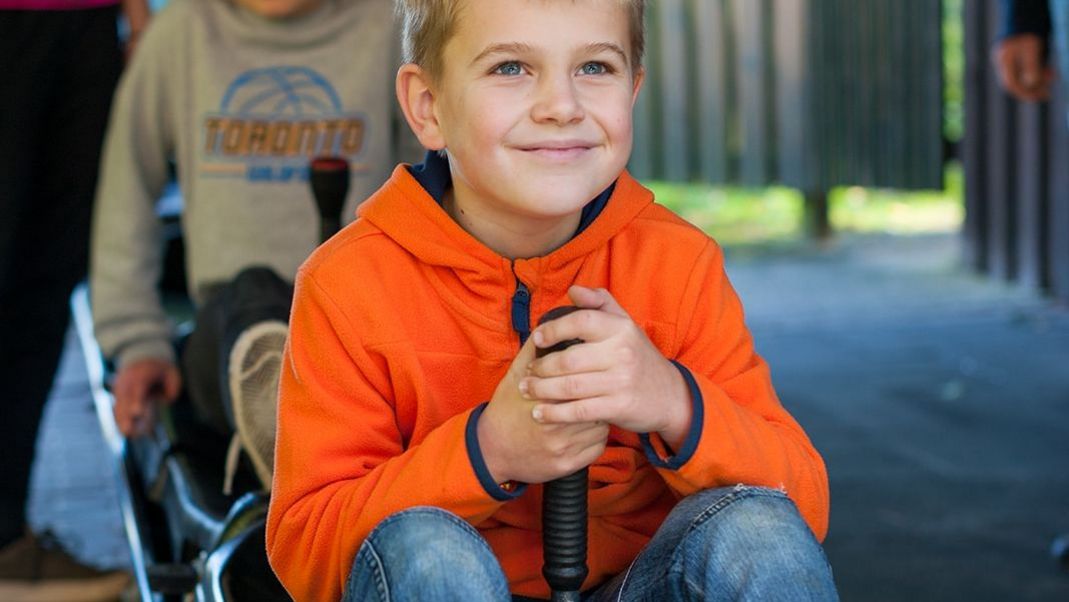 Junge sitzt auf einem Schlitten im Startbereich der Sommerrodelbahn Wingst