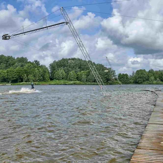 Blick auf den Ostesee mit der Wasserskianlage und eimem Wasserskifahrer