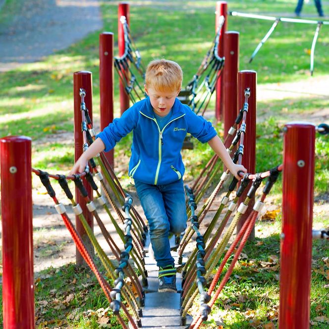 Kind balanciert auf dem Niedrigseilgarten 