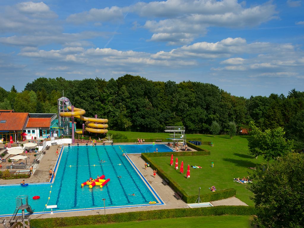 Das Bild zeigt eine Luftaufnahme des Hallen- und Freibades Wingst mit dem großen Schwimmbecken, der Rutsche und dem Außengelände.