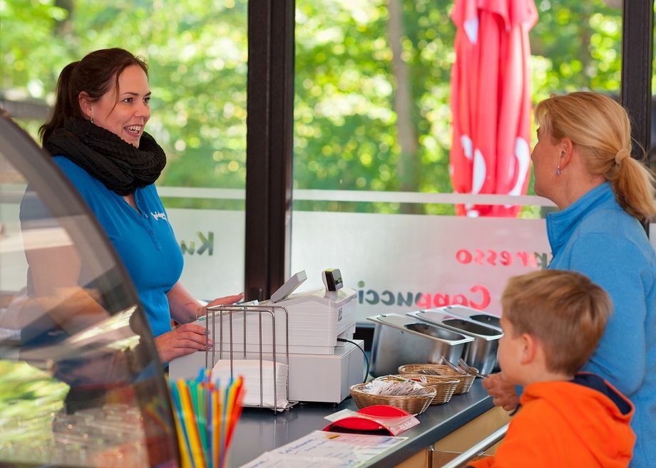 Mutter und Kind mit Servicekraft im Bistro Spielpark Wingst